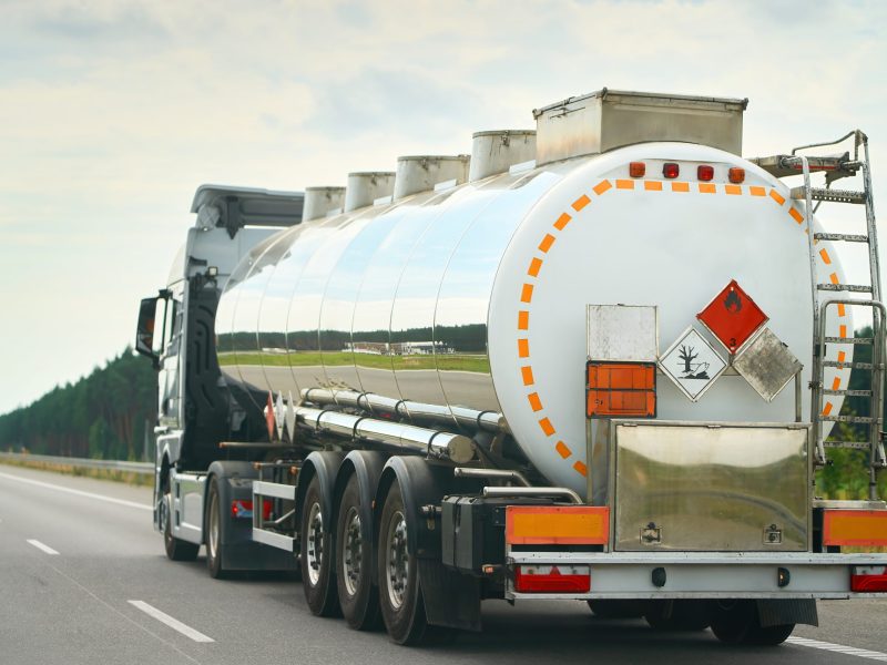 Truck hauling hazardous liquid cargo down road